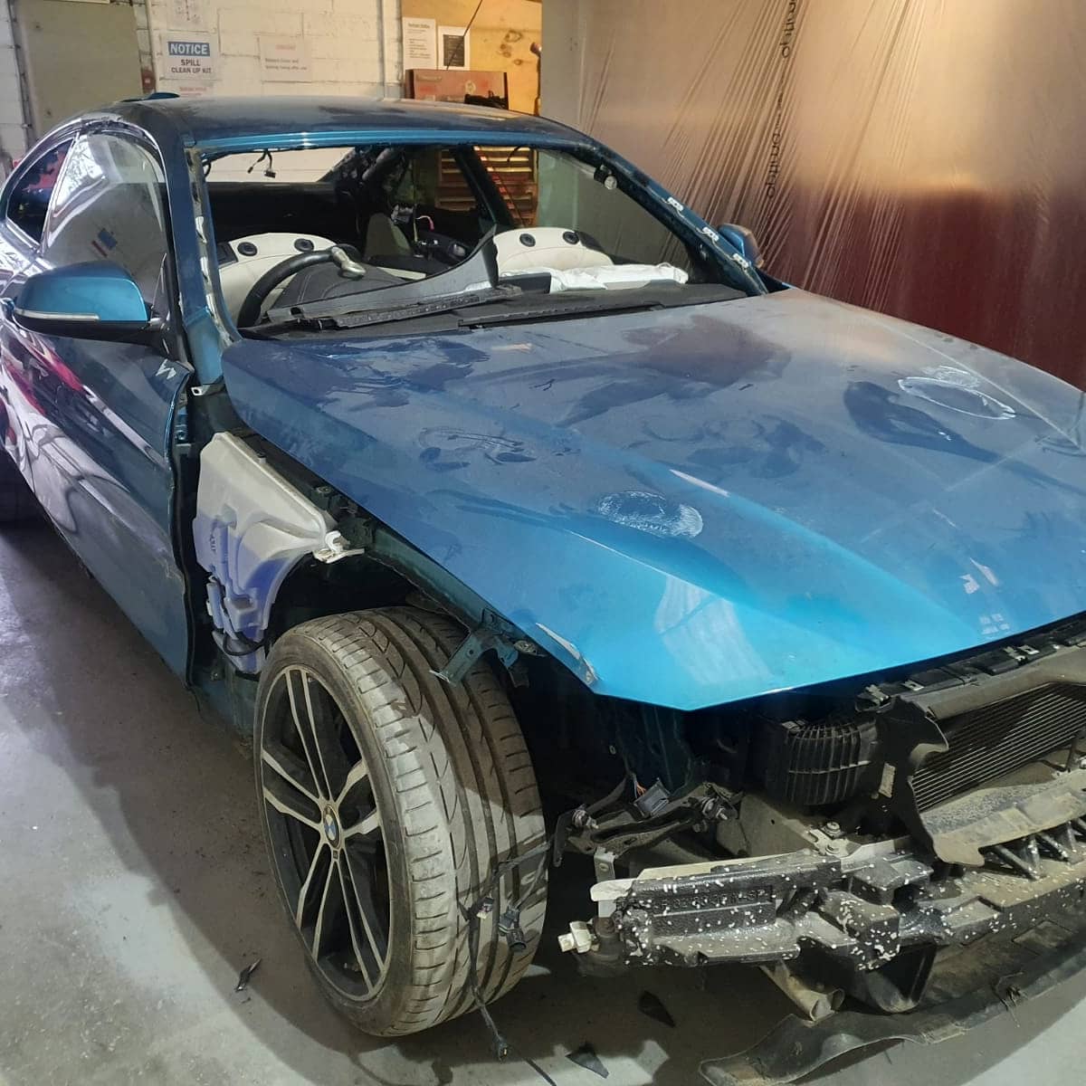 Blue BMW in workshop with front panels removed